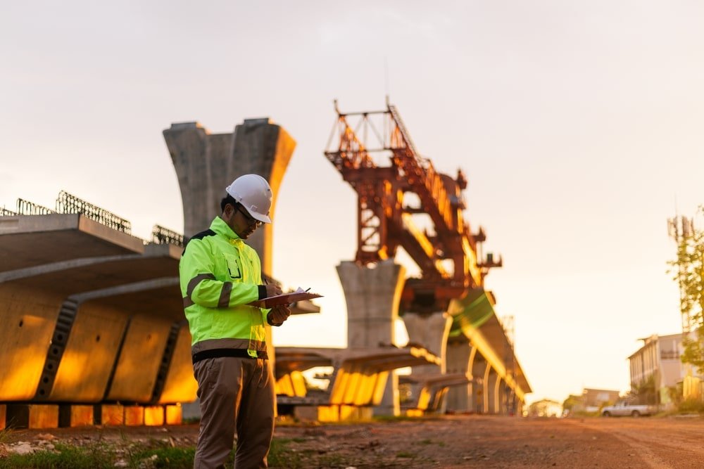 A,Construction,Worker,Is,Standing,On,A,Bridge,,Talking,On